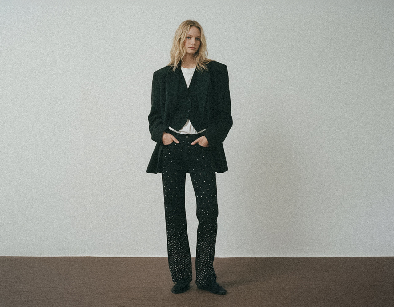 Model in High Rise Rhinestone Embellished Wide Leg Jeans and White Shirt with Black Vest and Blazer, linking to Flying Monkey best sellers collection.